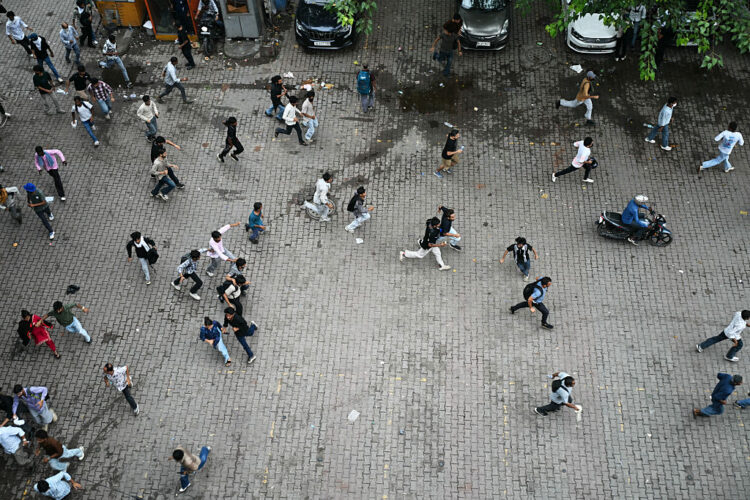 Cockroach Janta Party (CJP) supporters run as police fire tear gas shells to disperse them during a protest demanding the resignation of India's Education Minister Dharmendra Pradhan over alleged NEET exam irregularities in New Delhi on July 20, 2026. Indian police fired tear gas and baton-charged protesters in New Delhi on July 20, as they tried to march on parliament to demand the resignation of the education minister over irregularities in major examinations. (Photo by Sajjad HUSSAIN / AFP via Getty Images)